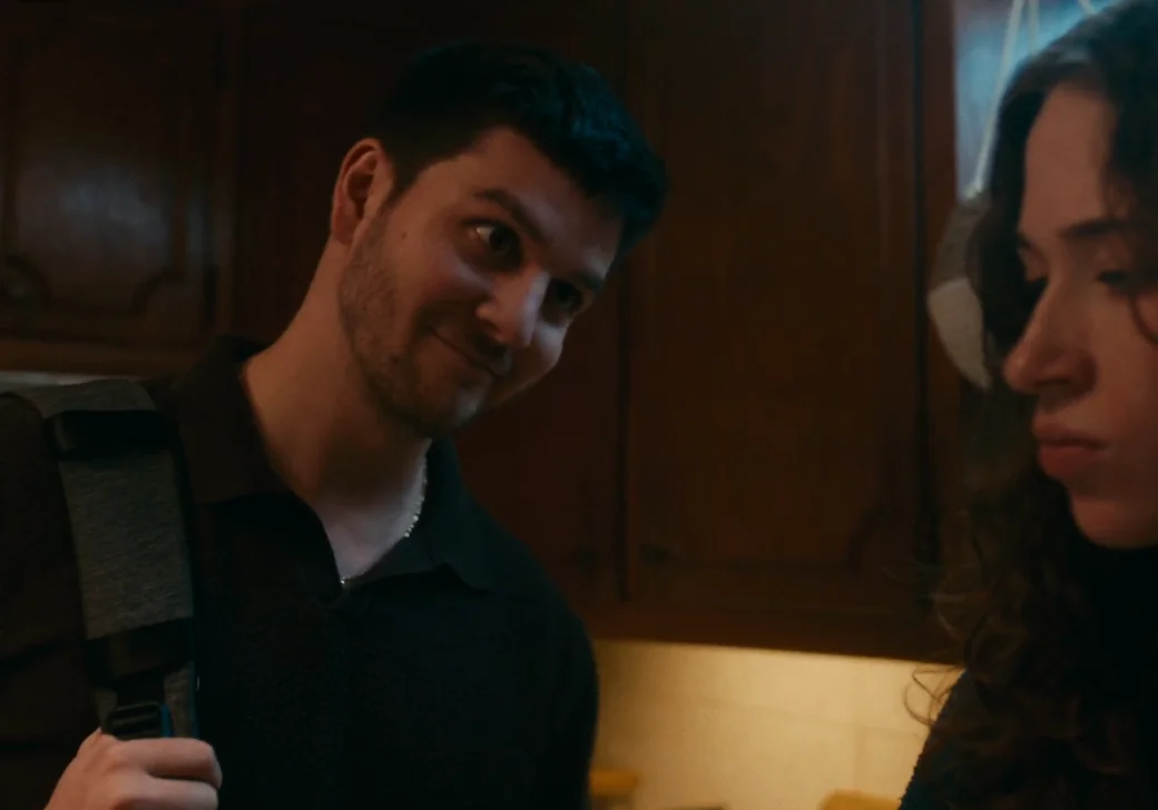 Man glancing sideways at a woman in a warmly lit kitchen